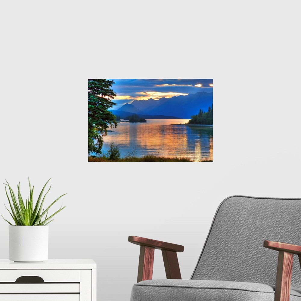 A modern room featuring A landscape photograph of morning light reflecting on a lake in the mountains surrounded by trees.