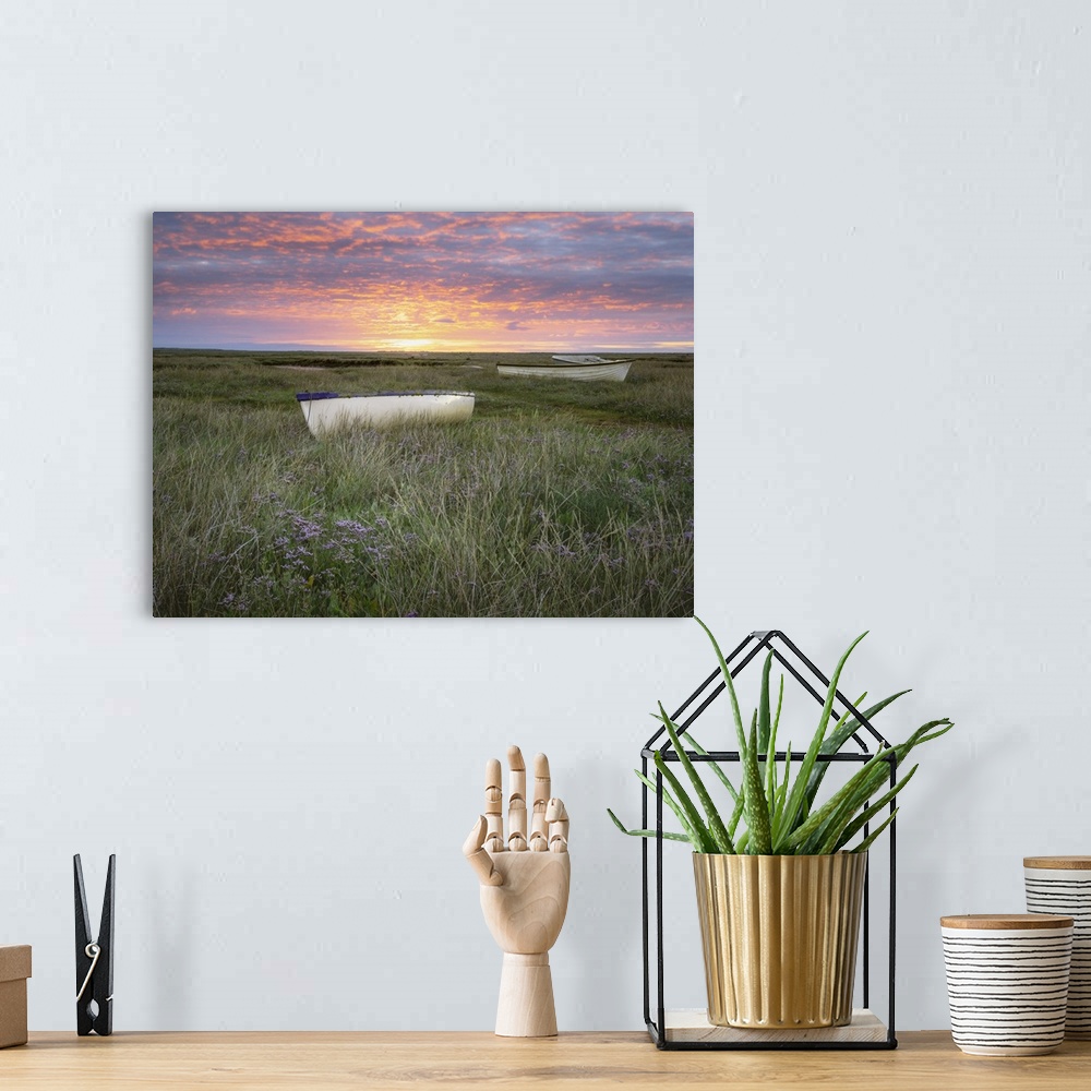 A bohemian room featuring Sunrise over small boats on the salt marsh surrounded by sea lavender.
