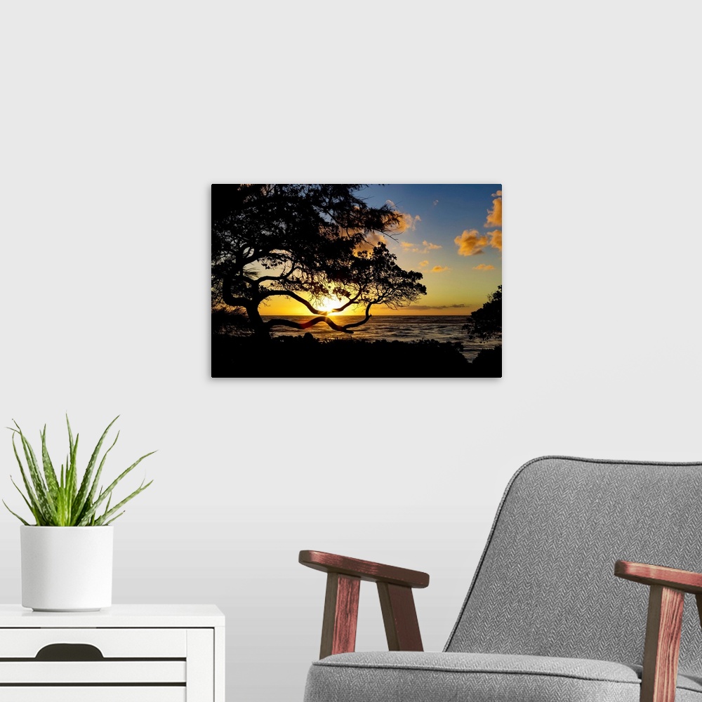 A modern room featuring Sunrise over the ocean from the coast of Kauai; Kauai, Hawaii, United States of America