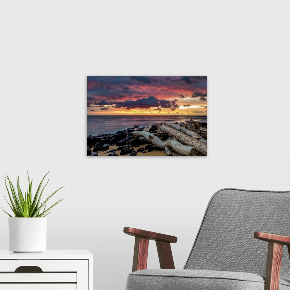 A modern room featuring Sunrise over the Pacific Ocean from the shore of Lydgate Beach; Kapaa, Kauai, Hawaii, United Stat...