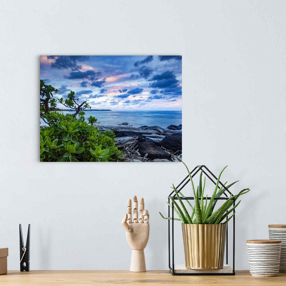 A bohemian room featuring Sunrise over the Pacific Ocean from the rocks on the shore of Lydgate Beach; Kapaa, Kauai, Hawaii...