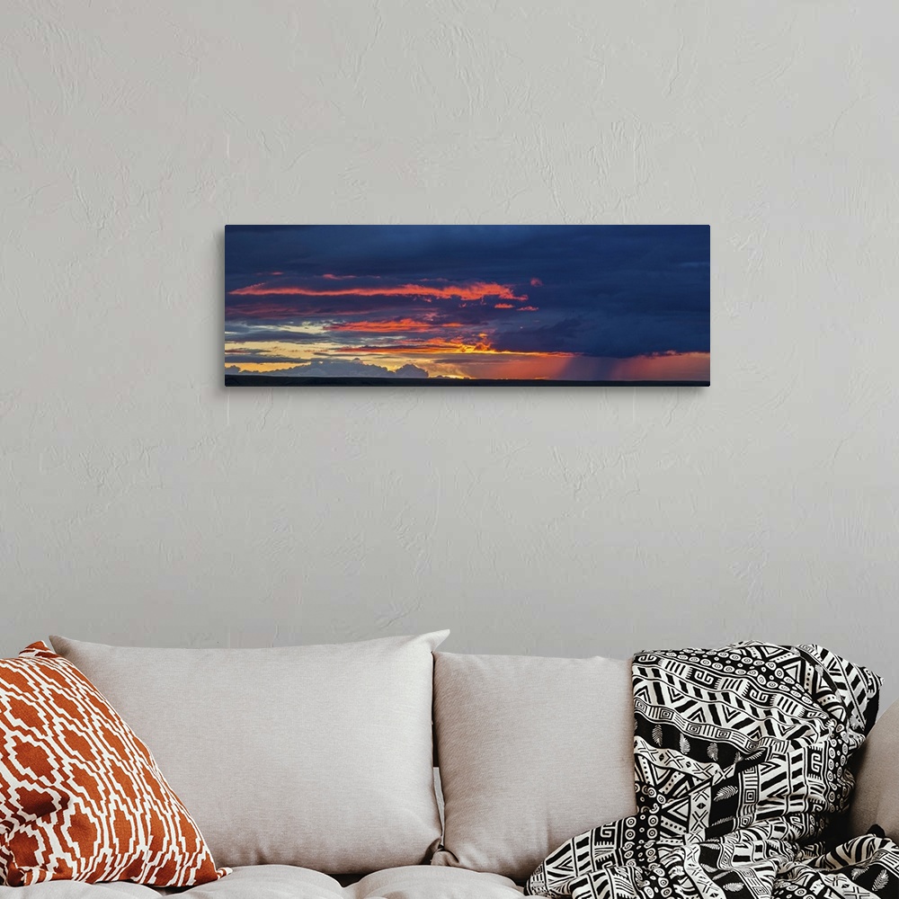 A bohemian room featuring Panoramic view of sunset lit clouds and a rain shower over Grasslands National Park, Saskatchewan...