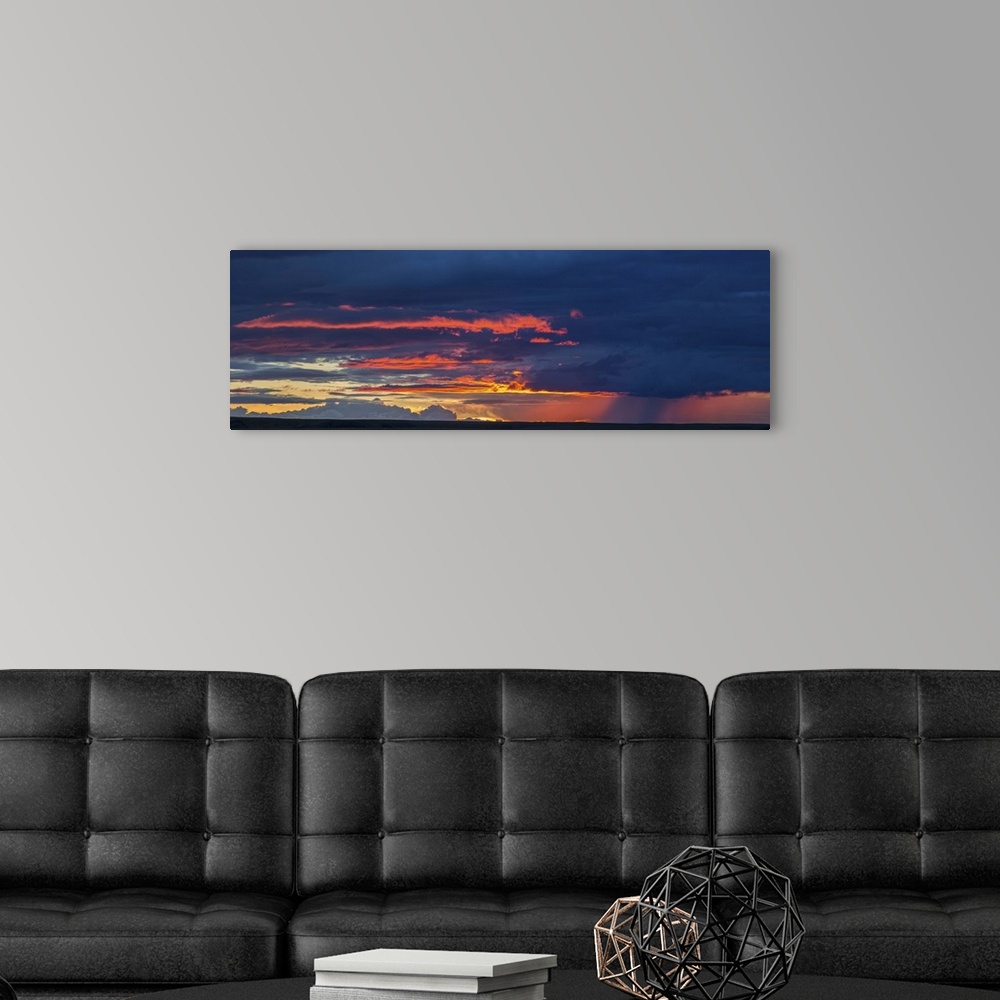 A modern room featuring Panoramic view of sunset lit clouds and a rain shower over Grasslands National Park, Saskatchewan...