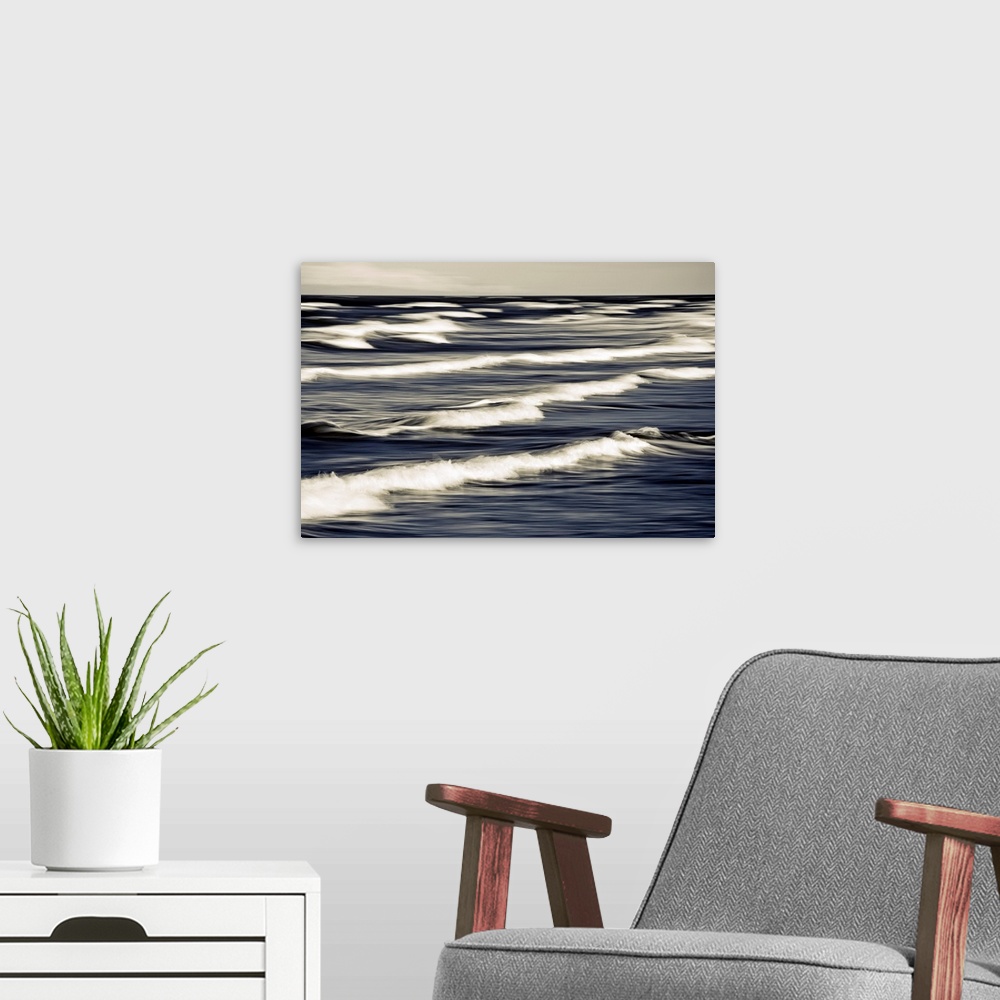 A modern room featuring Big photo on canvas of waves breaking up close in the ocean.