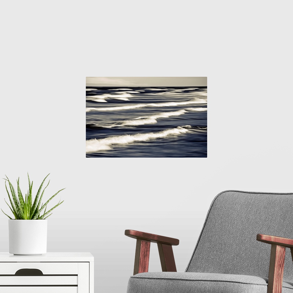 A modern room featuring Big photo on canvas of waves breaking up close in the ocean.