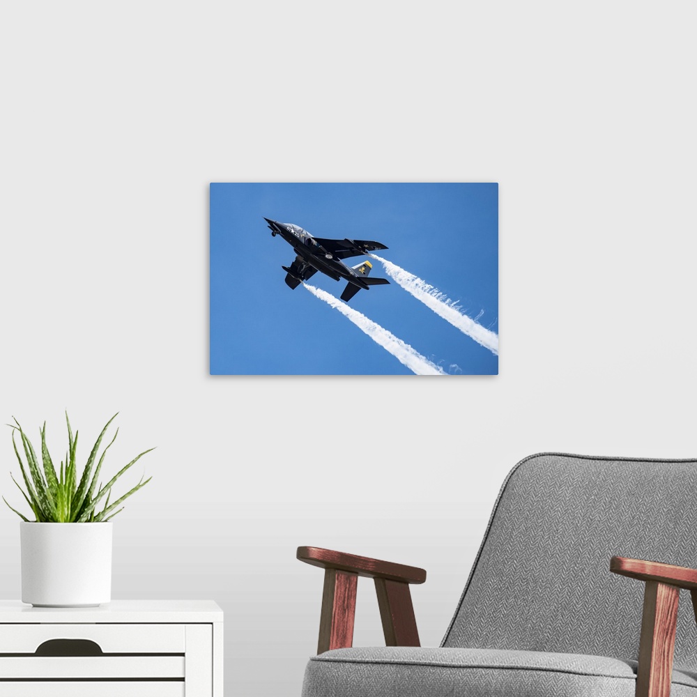 A modern room featuring The 1981 DORNIER GMBH ALPHA-JET trailing smoke while performing aerobatic manoeuvres with landing...