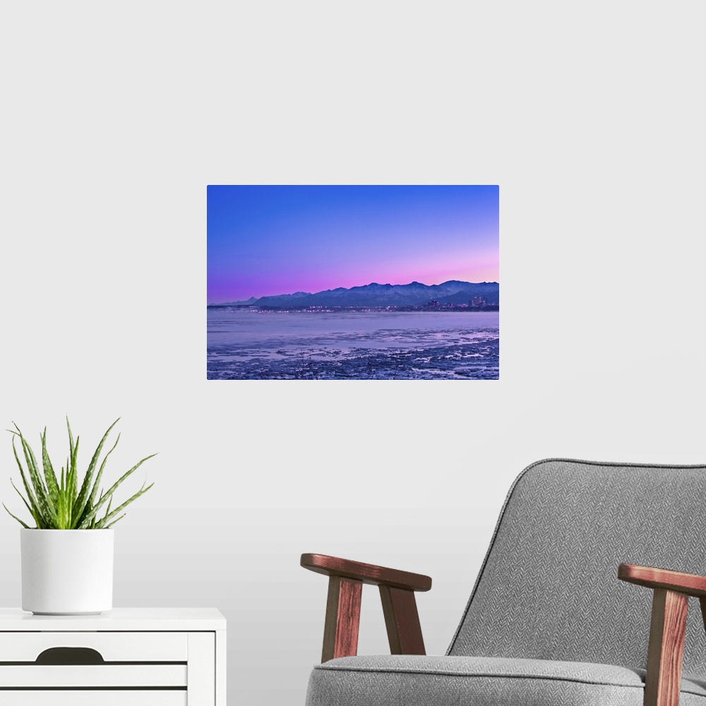 A modern room featuring The Anchorage Skyline before dawn with fog rising from the waters of Knik Arm as seen from Earthq...