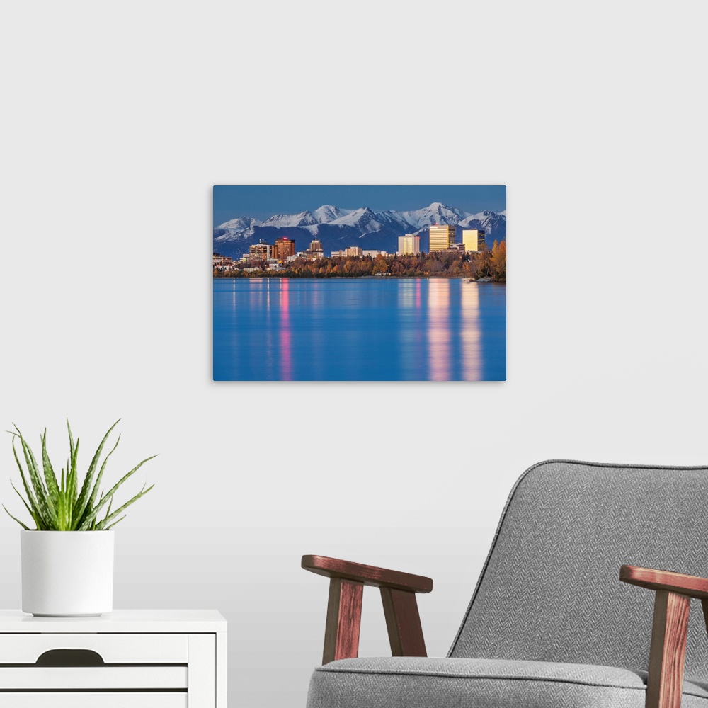 A modern room featuring The Anchorage Skyline with the city lights reflected in the water of Knik Arm at high tide, Snow ...