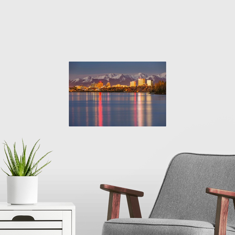 A modern room featuring The Anchorage Skyline with the city lights reflected in the water of Knik Arm at high tide, Snow ...