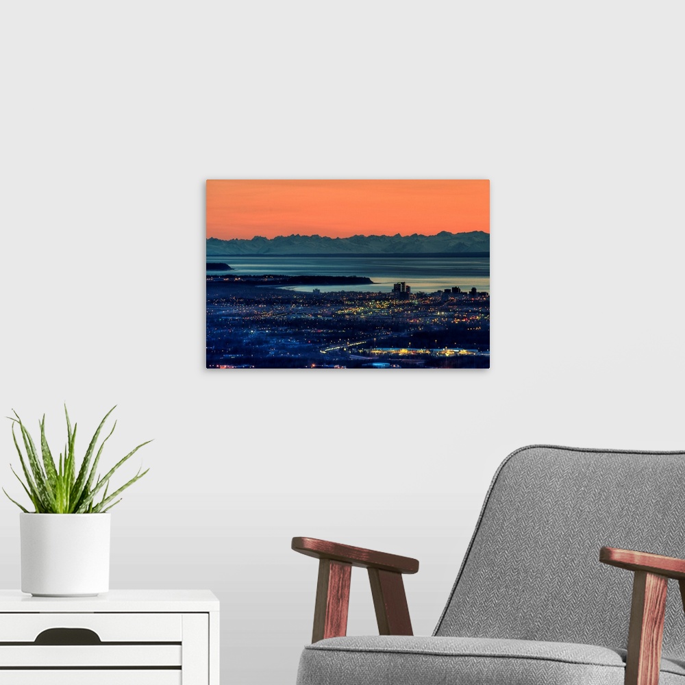 A modern room featuring The city of Anchorage Alaska at sunset with Cook Inlet in the background