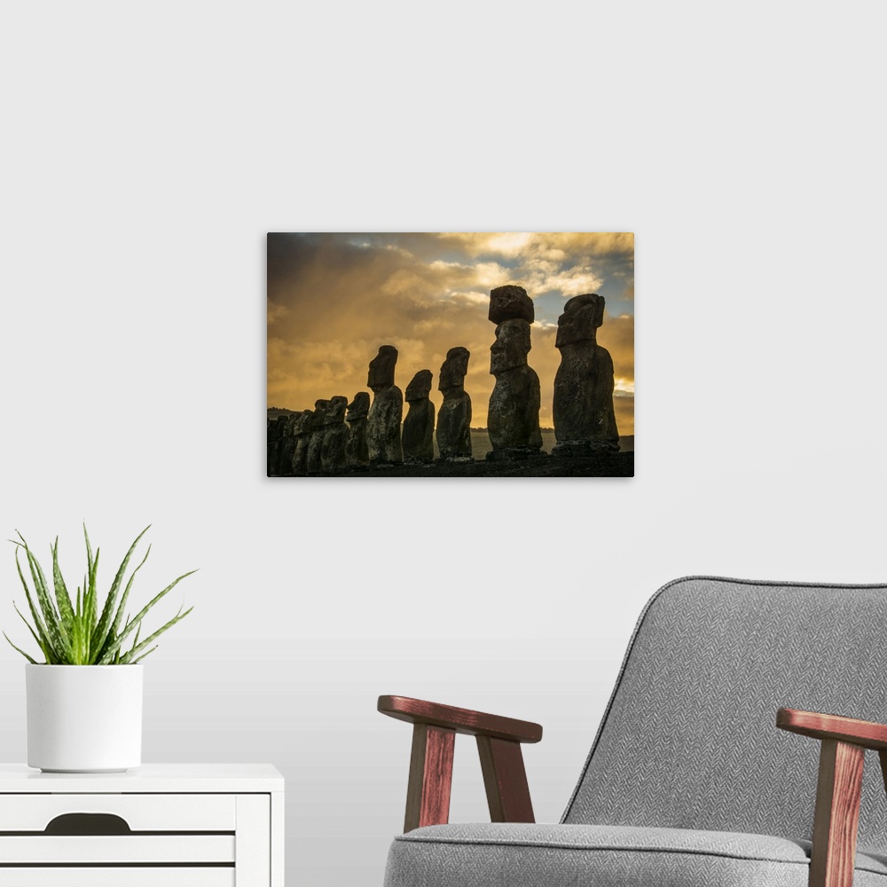 A modern room featuring The fifteen moais of Tongariki close-up in decreasing perspective against a colourful sunrise; Ea...