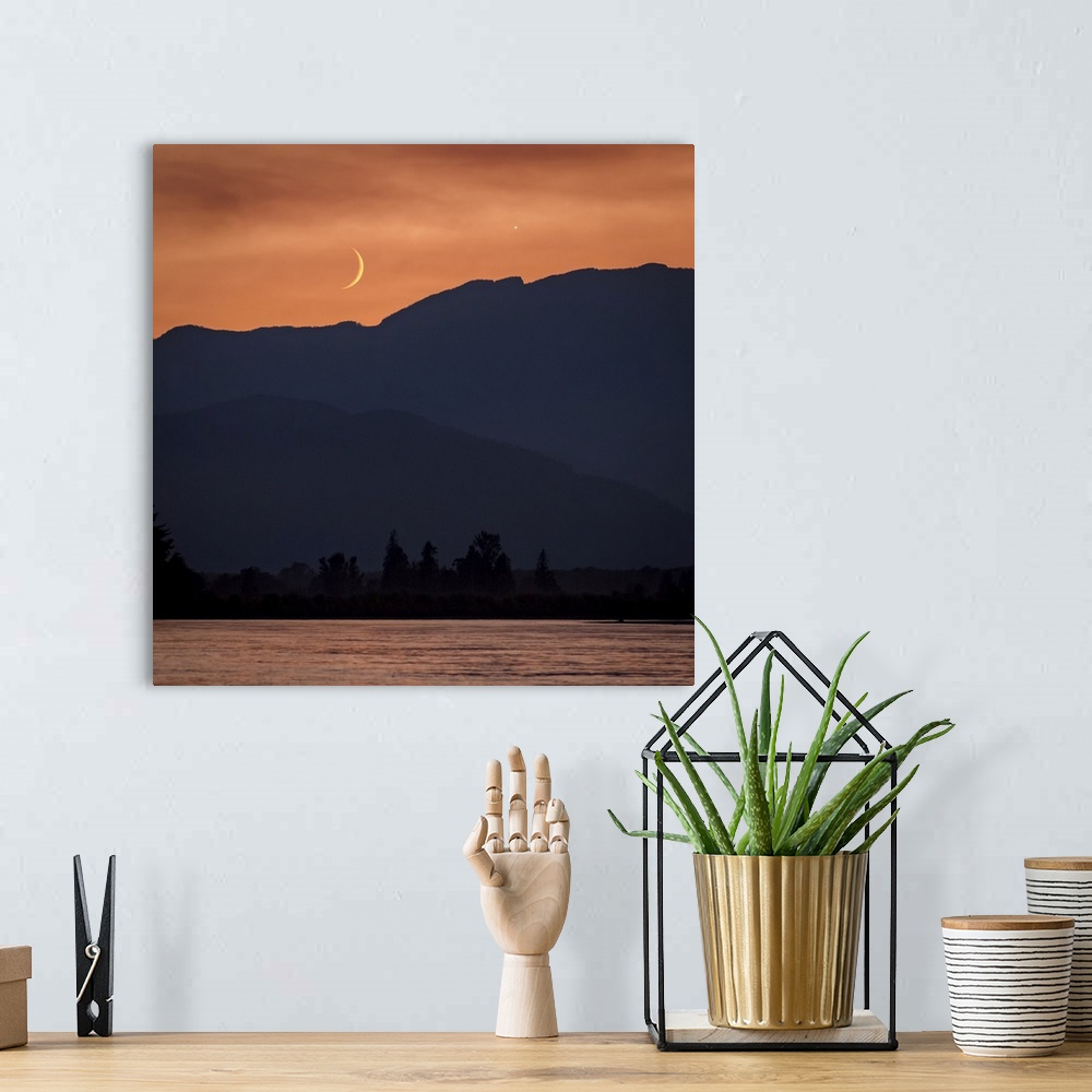 A bohemian room featuring The moon and Venus in an orange sky over the silhouetted mountains, Fraser Valley; Vancouver, Bri...