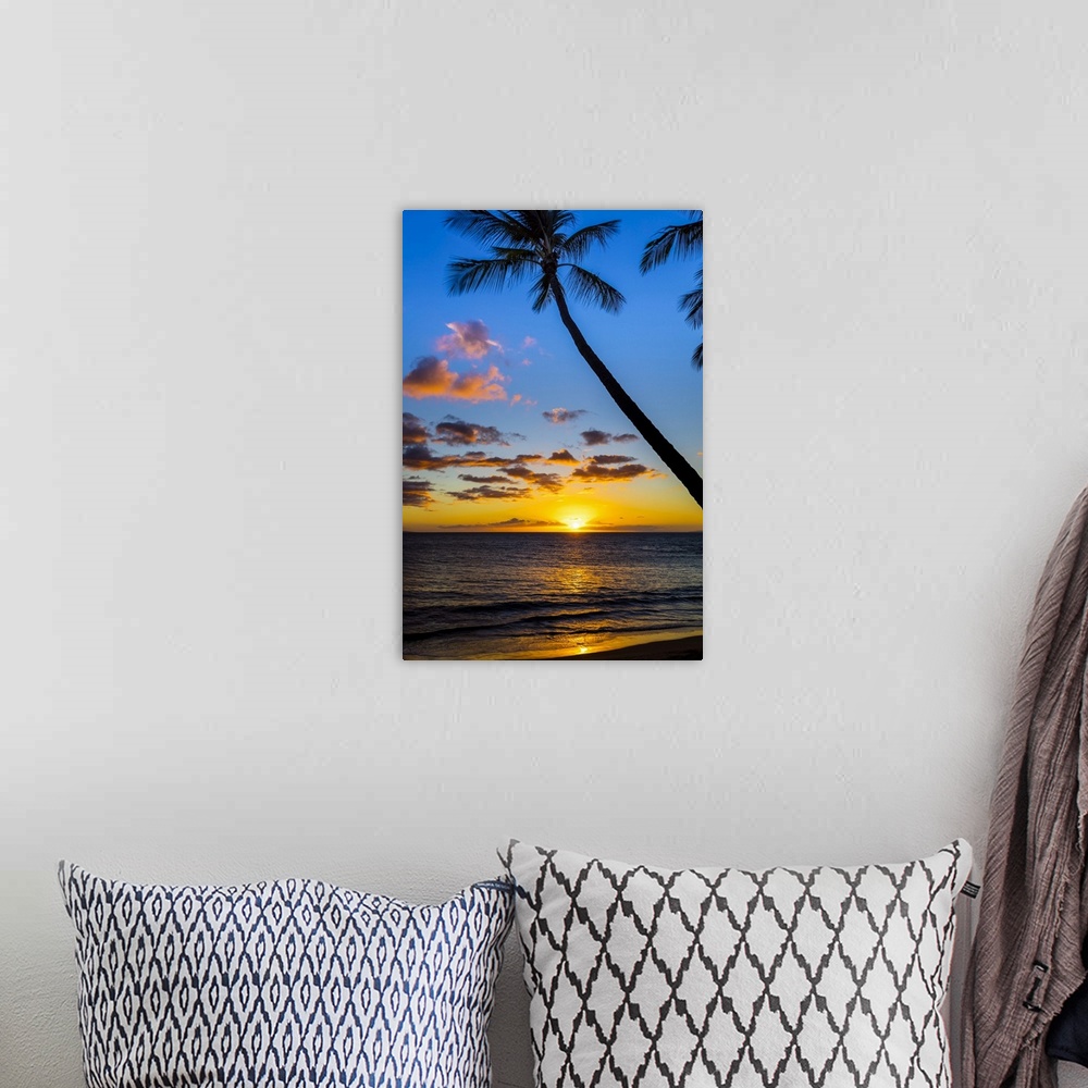 A bohemian room featuring The sun setting through silhouetted palm trees; Wailea, Maui, Hawaii, United States of America