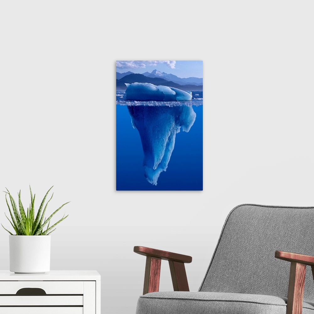 A modern room featuring A composite photograph of a large Iceberg as seen from under and above the water.