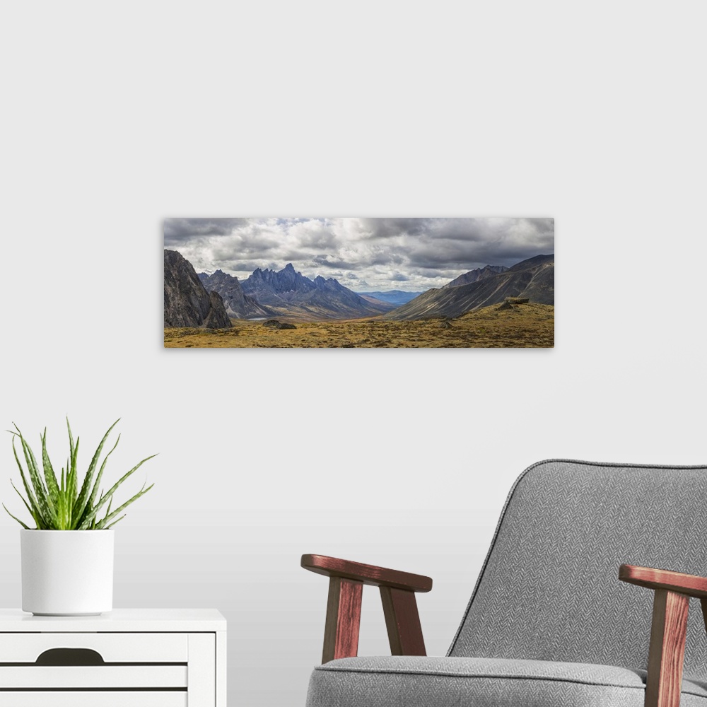 A modern room featuring Men standing on a boulder in the distance in Tombstone Territorial Park in autumn. Yukon, Canada.