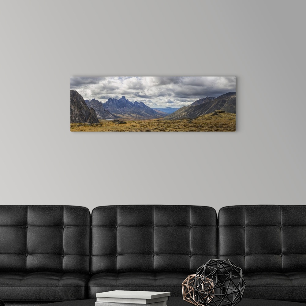 A modern room featuring Men standing on a boulder in the distance in Tombstone Territorial Park in autumn. Yukon, Canada.