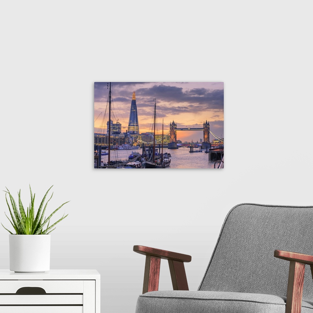 A modern room featuring Tower Bridge and The Shard along the River Thames at sunset.