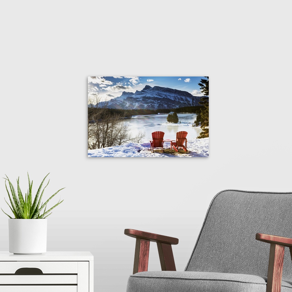 A modern room featuring Two Red Chairs On Snow Covered Ridge Overlooking Frozen Lake, Banff, Alberta, Canada