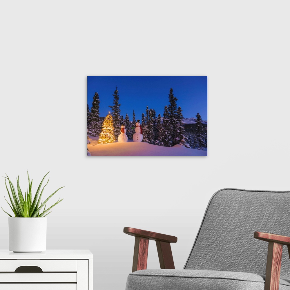A modern room featuring Two snowmen exchanging gifts standing next to a Christmas tree