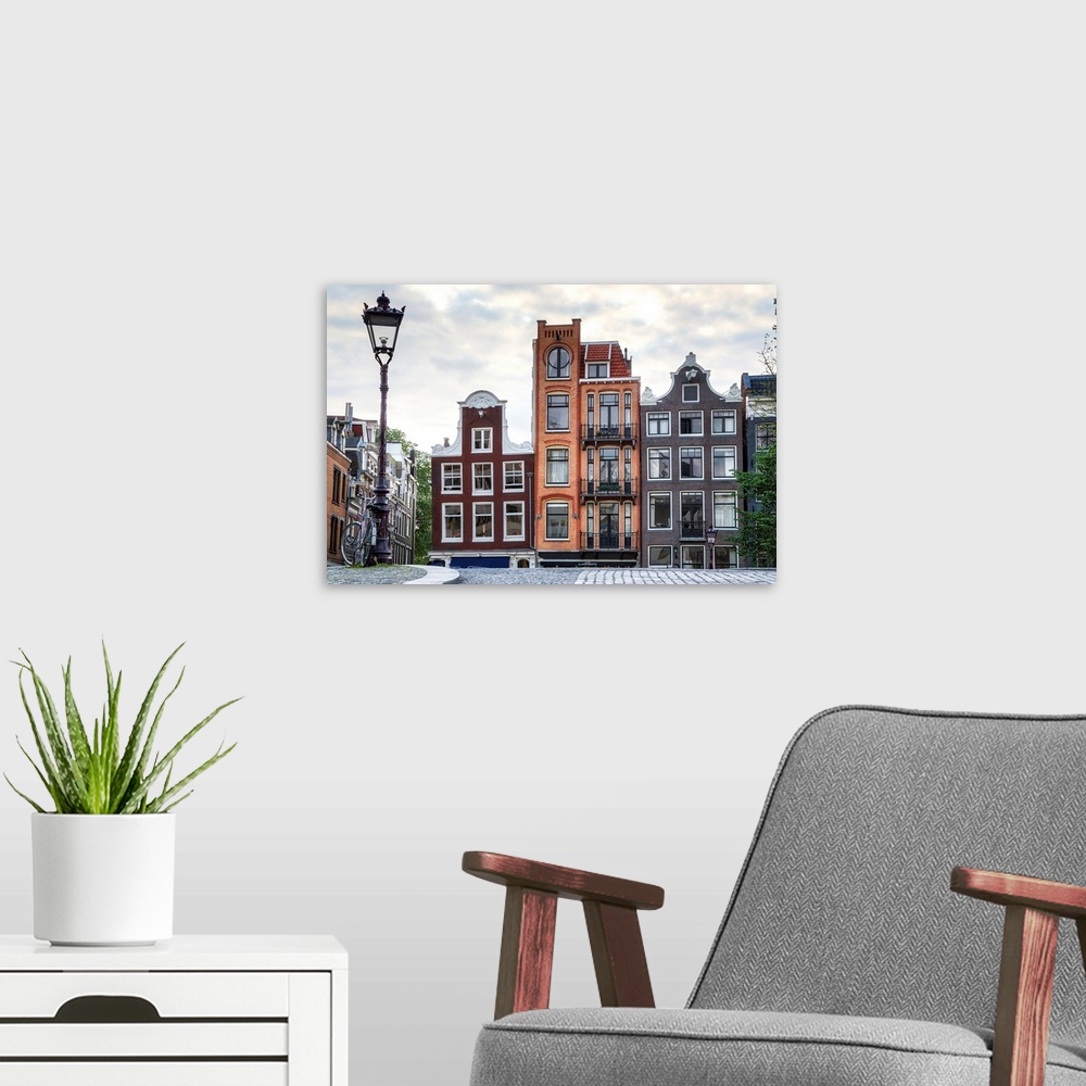 A modern room featuring Unique residential buildings and a lamp post; Amsterdam, Netherlands