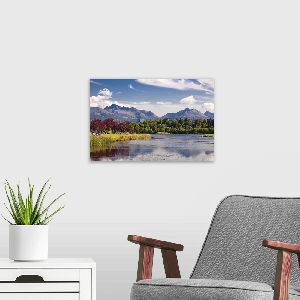 A modern room featuring Giant, landscape photograph of the Westchester Lagoon in the summer, surrounded by trees, and the...