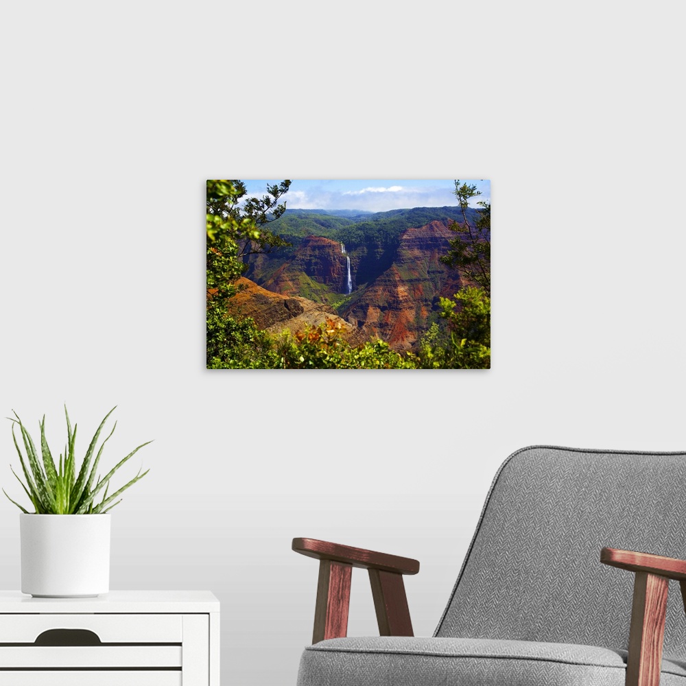 A modern room featuring Waimea Canyon Falls and lush foliage on rugged cliffs and mountains; Waimea, Kauai, Hawaii, Unite...