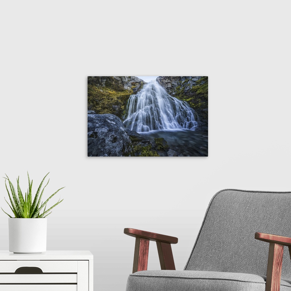 A modern room featuring Waterfall along the road, west fjords, Iceland.