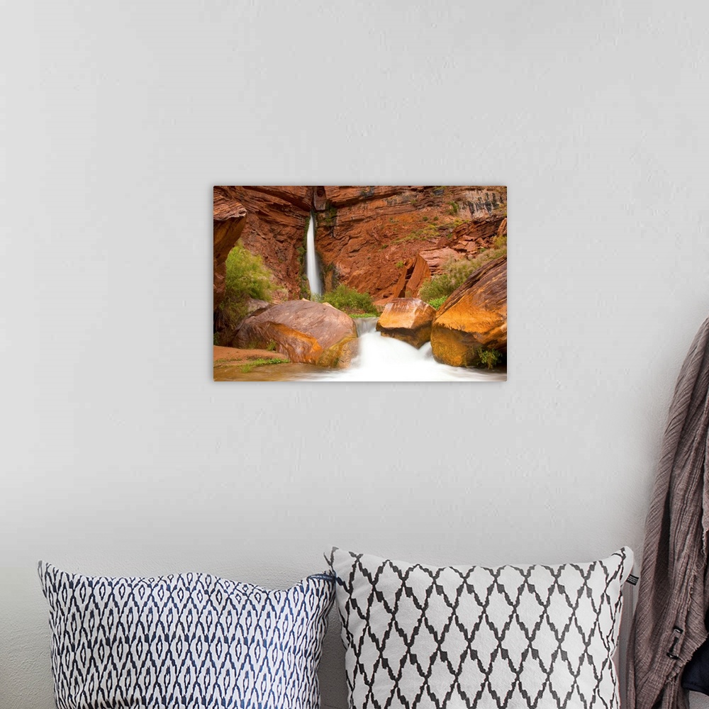 A bohemian room featuring Waterfall from a narrow crevass in a sandstone cliff.