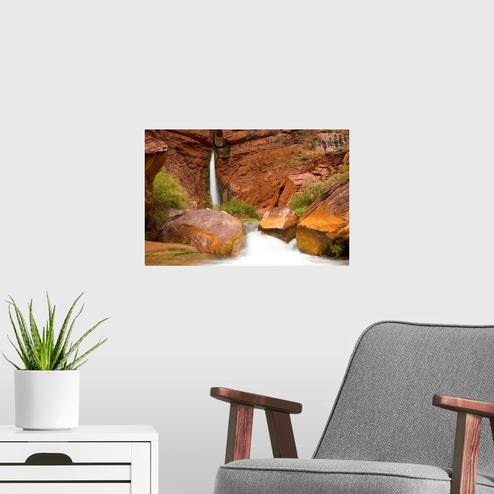 A modern room featuring Waterfall from a narrow crevass in a sandstone cliff.