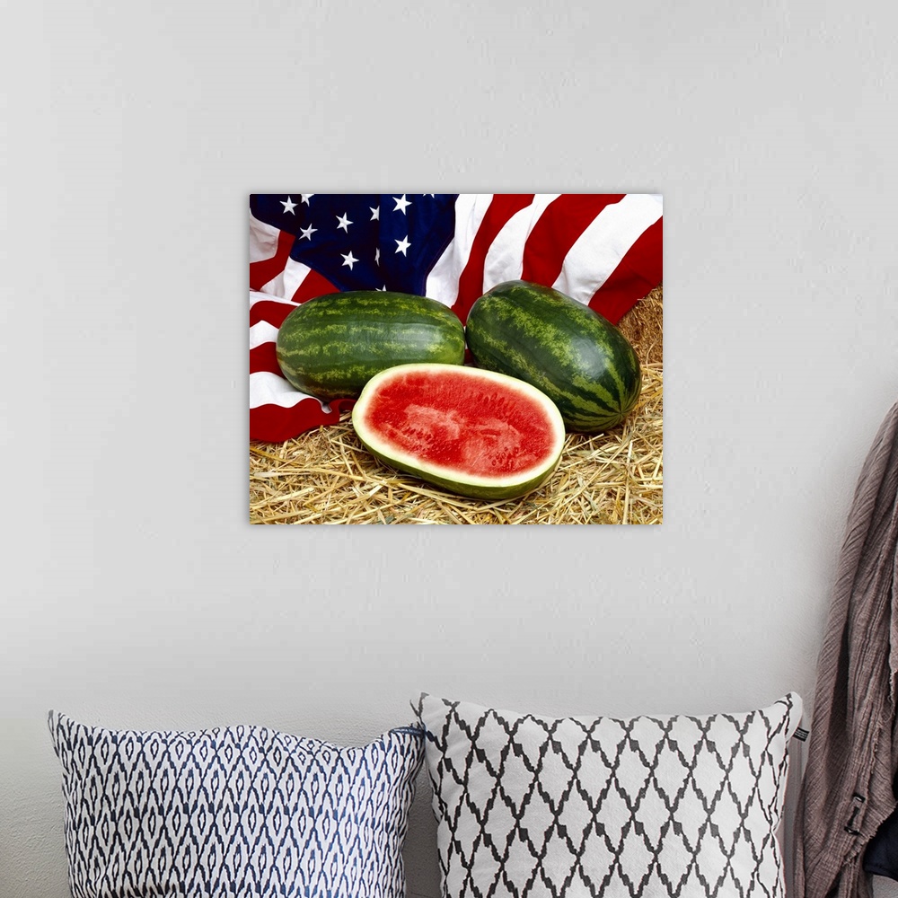 A bohemian room featuring Whole and sliced watermelons on hay, with the American Flag