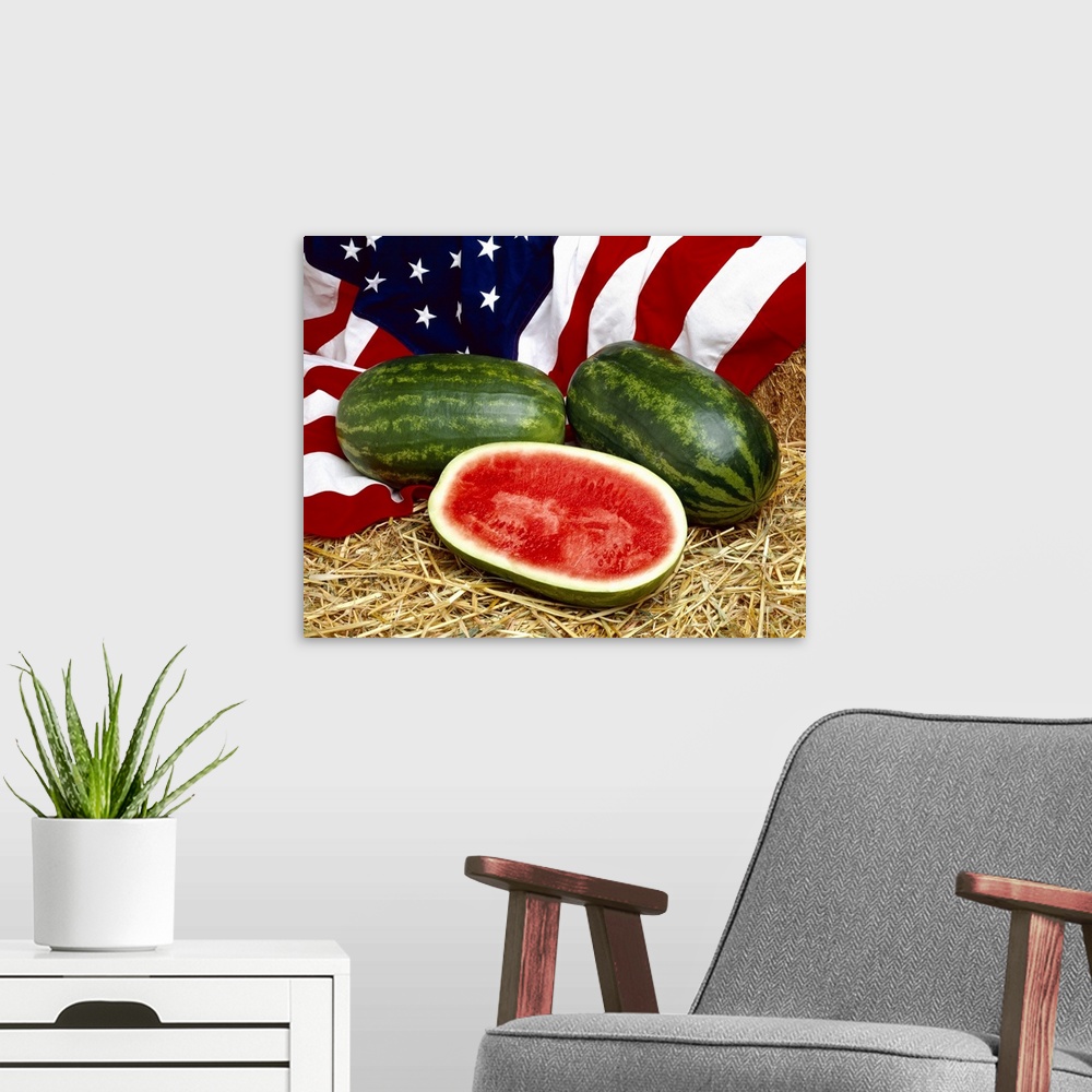 A modern room featuring Whole and sliced watermelons on hay, with the American Flag