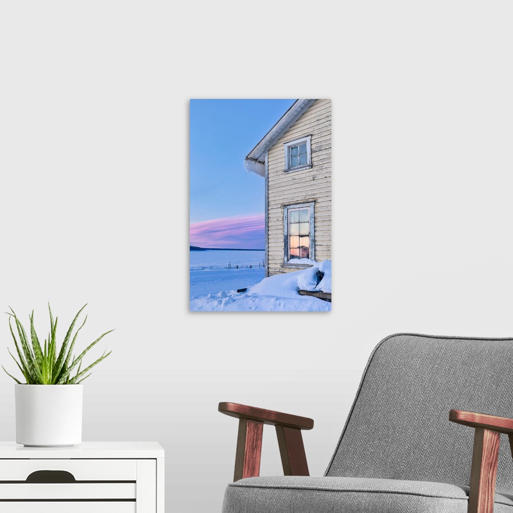 A modern room featuring Winter Sunrise on the horizon reflected in the window of Our Lady of the Snows Catholic Mission b...