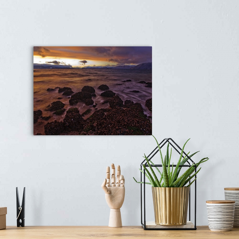 A bohemian room featuring The view North over Zimovia Strait from Petroglyph Beach at sunset as small waves move over the b...
