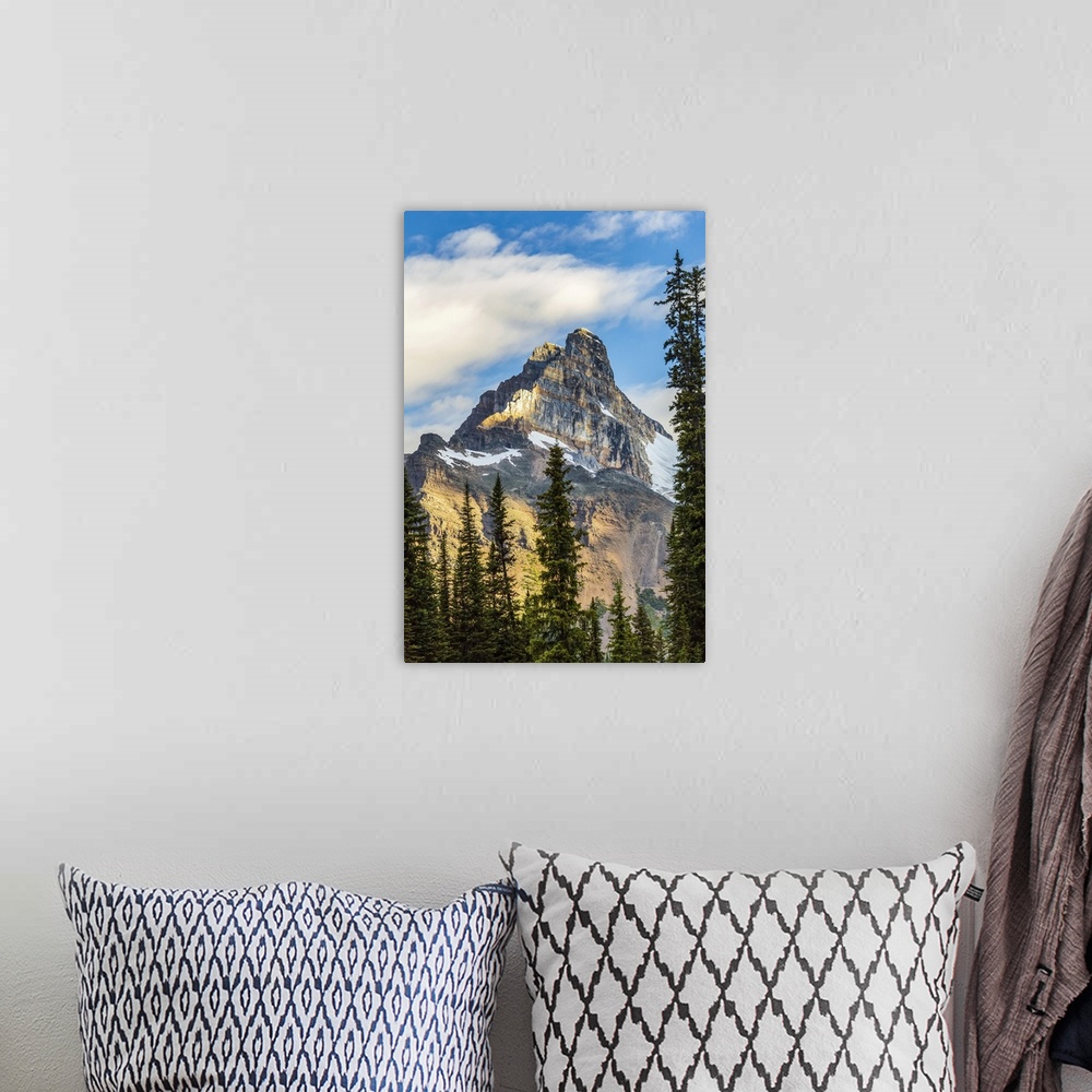 A bohemian room featuring Mountain cliff peak dramatically lit by the sun with blue sky and clouds, Yoho National Park; Fie...