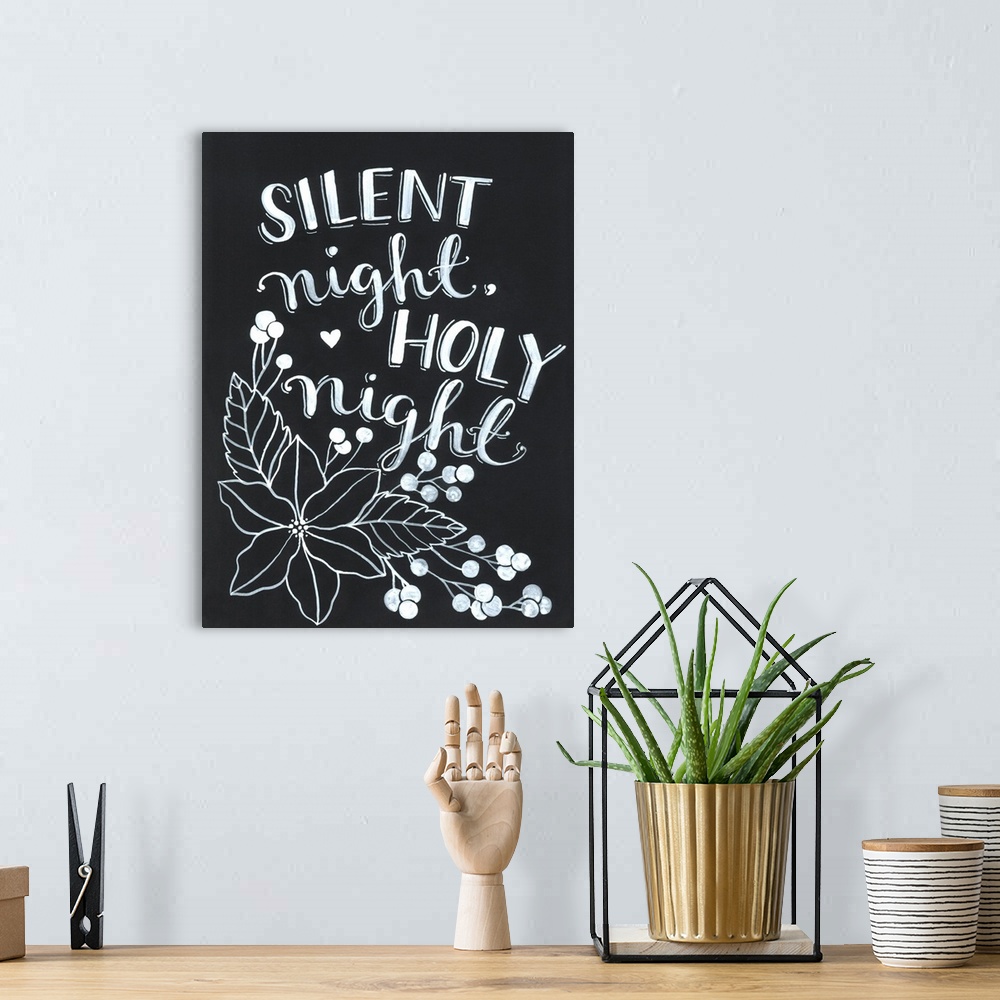 A bohemian room featuring The words "Silent night, holy night" handwritten on a dark background with a large poinsettia flo...