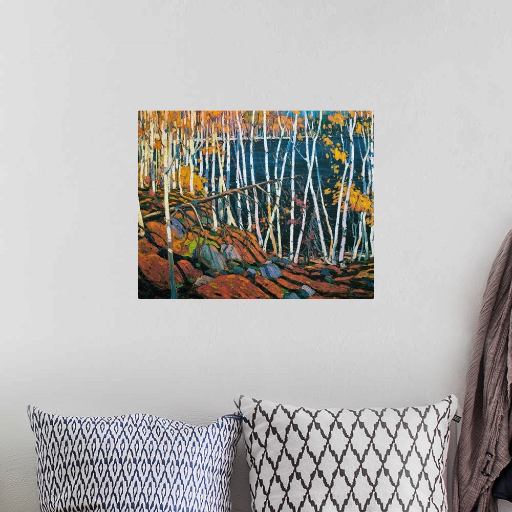 A bohemian room featuring A painting made on canvas of thin trees with rocks on the ground surrounding a lake.