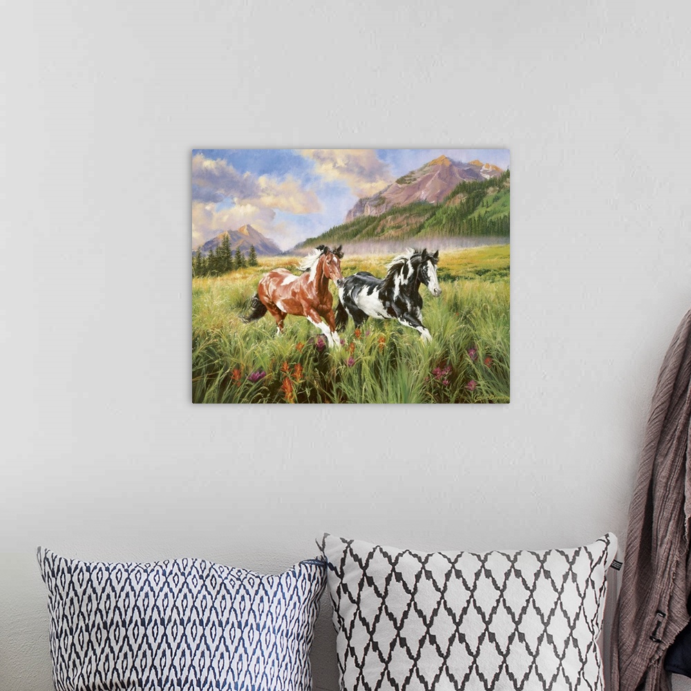 A bohemian room featuring Landscape artwork on a large canvas of two spotted horses running through a grassy field, large m...