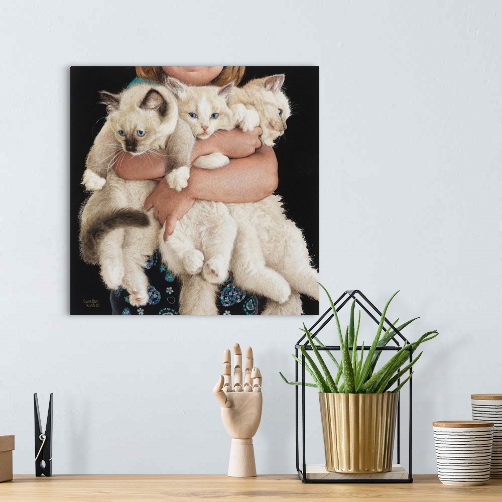 A bohemian room featuring An adorable image of a child holding three white fluffy kittens.