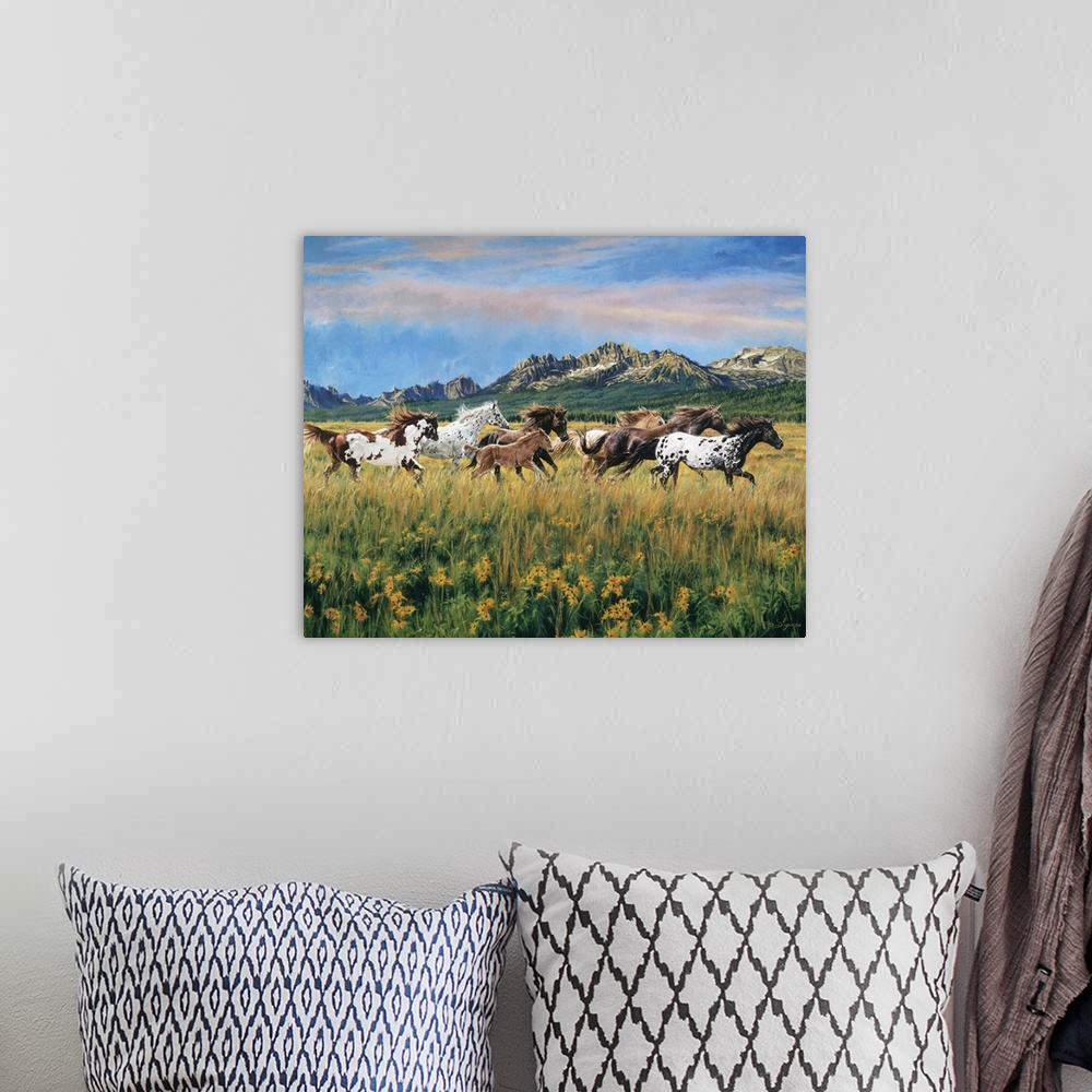 A bohemian room featuring Painting of wild horses running through a meadow of flowers and tall grass with mountains in the ...