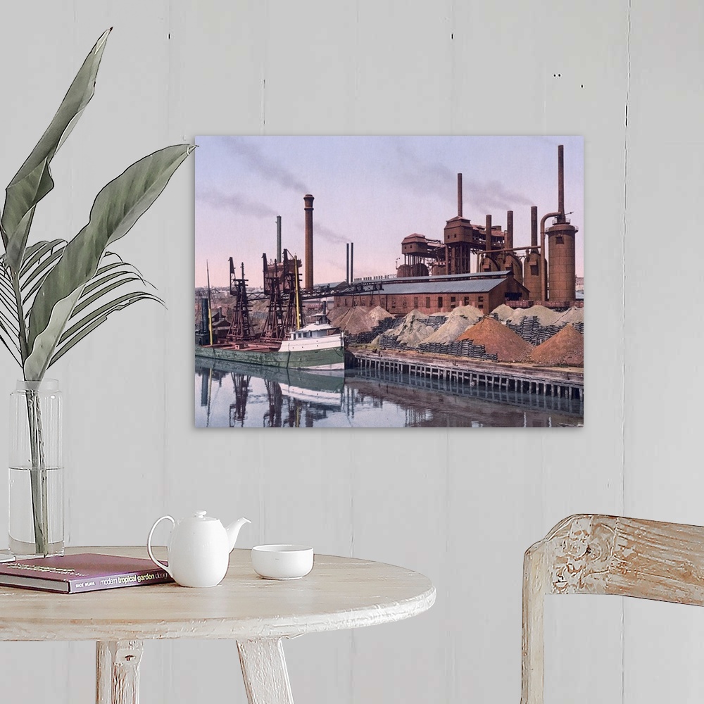 A farmhouse room featuring Vintage color photo of an American Steel factory on the banks of a river with tall smoke stacks a...
