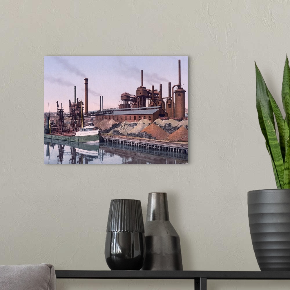 A modern room featuring Vintage color photo of an American Steel factory on the banks of a river with tall smoke stacks a...