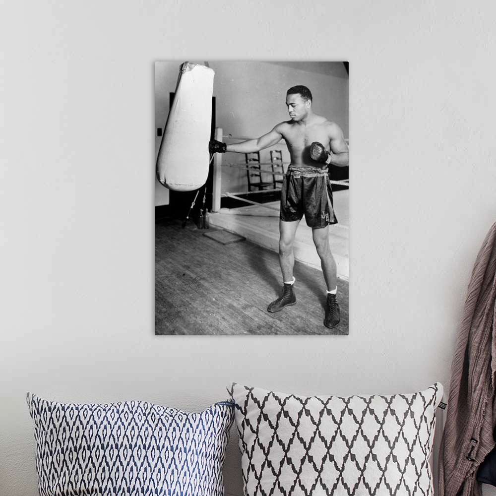 A bohemian room featuring circa 1938:  American light heavyweight world champion boxer, John Henry Lewis, training for his ...