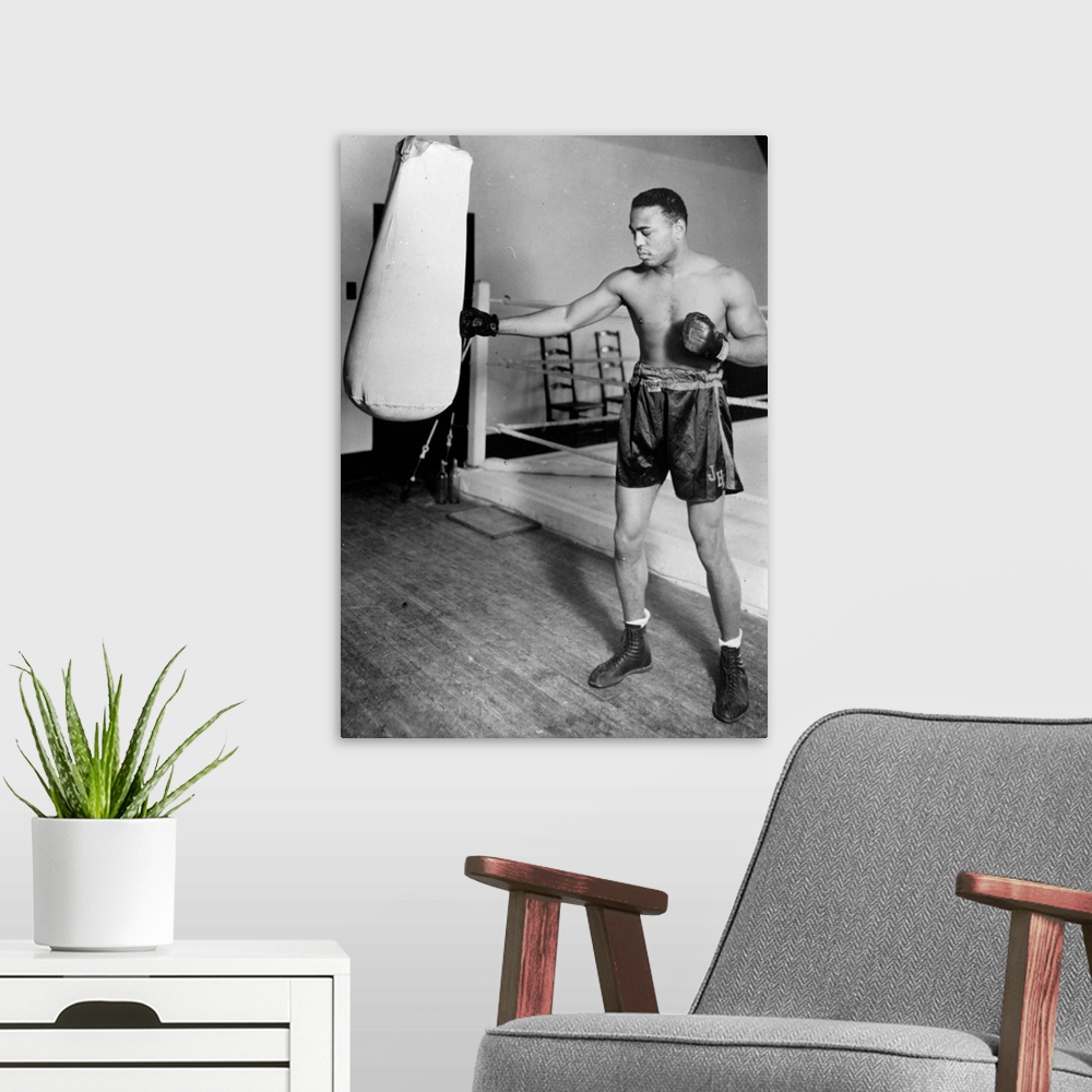 A modern room featuring circa 1938:  American light heavyweight world champion boxer, John Henry Lewis, training for his ...