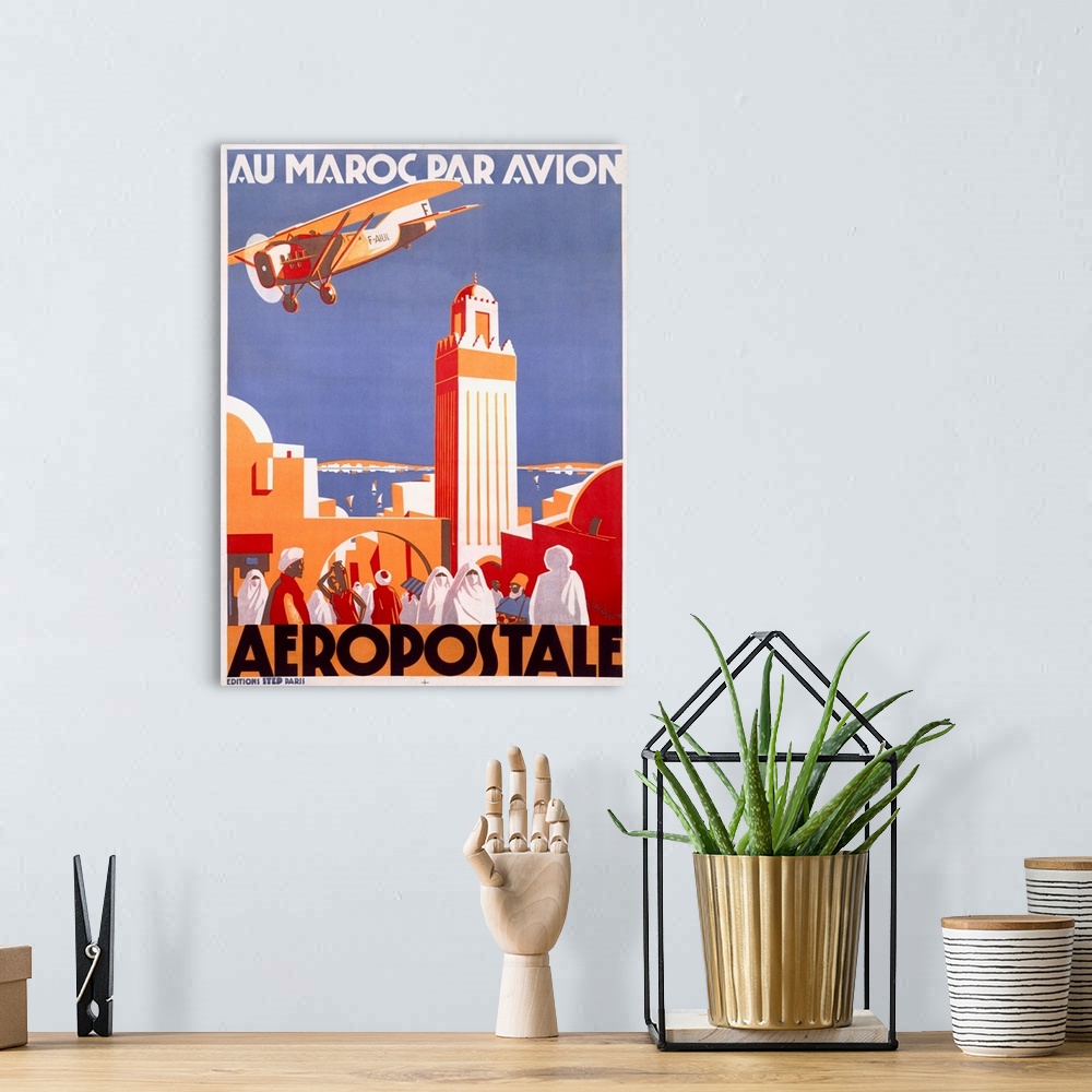 A bohemian room featuring Vintage travel poster highlighting the Moroccan Aeropostale airline with a single engine plane fl...