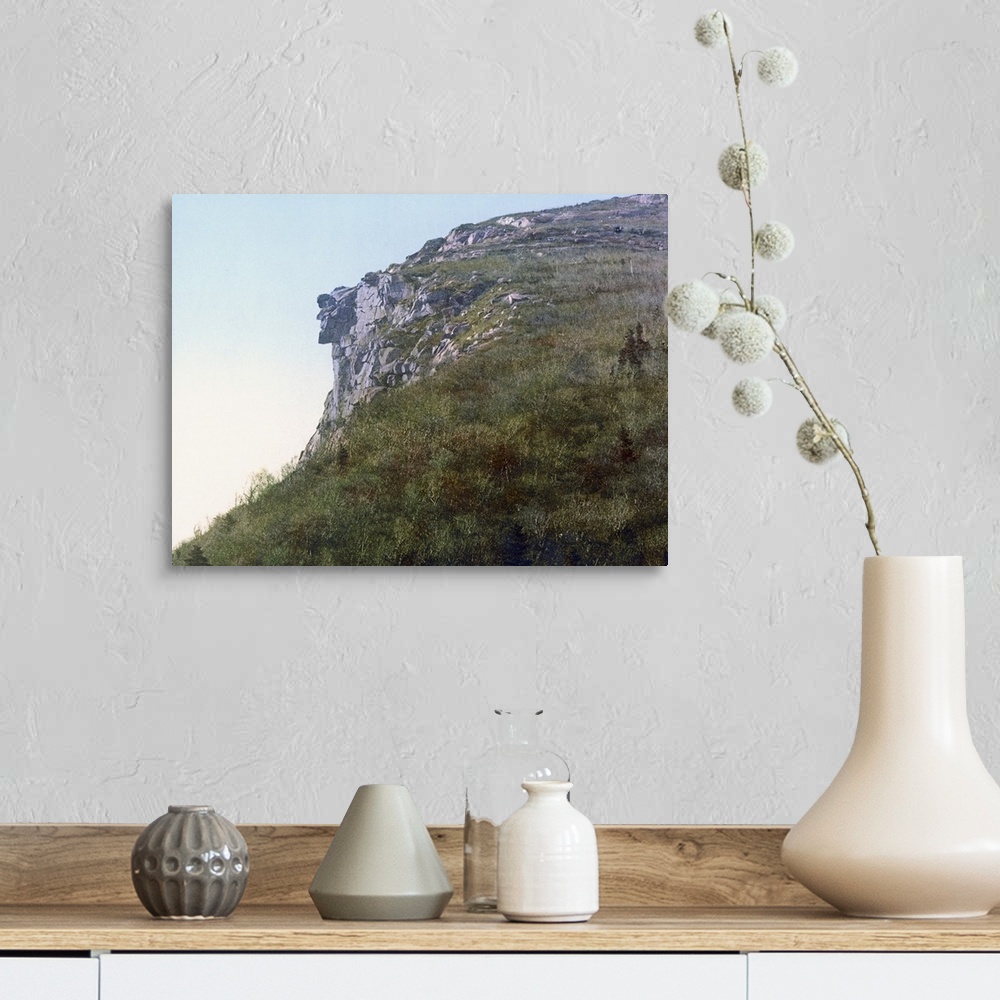 A farmhouse room featuring Photo on canvas of the face of a man made out of rocks hanging on a cliff of a mountain.