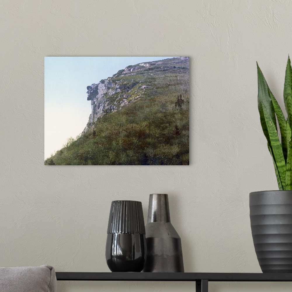 A modern room featuring Photo on canvas of the face of a man made out of rocks hanging on a cliff of a mountain.