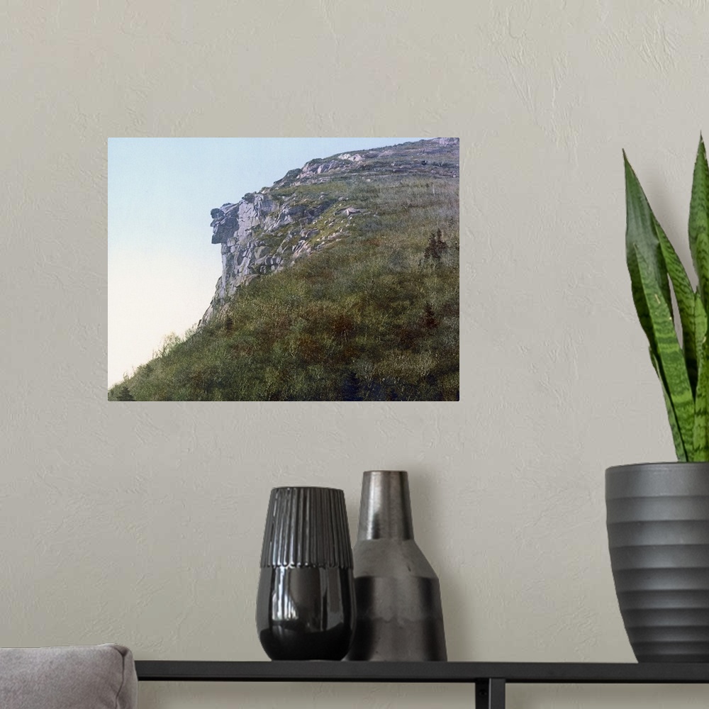 A modern room featuring Photo on canvas of the face of a man made out of rocks hanging on a cliff of a mountain.