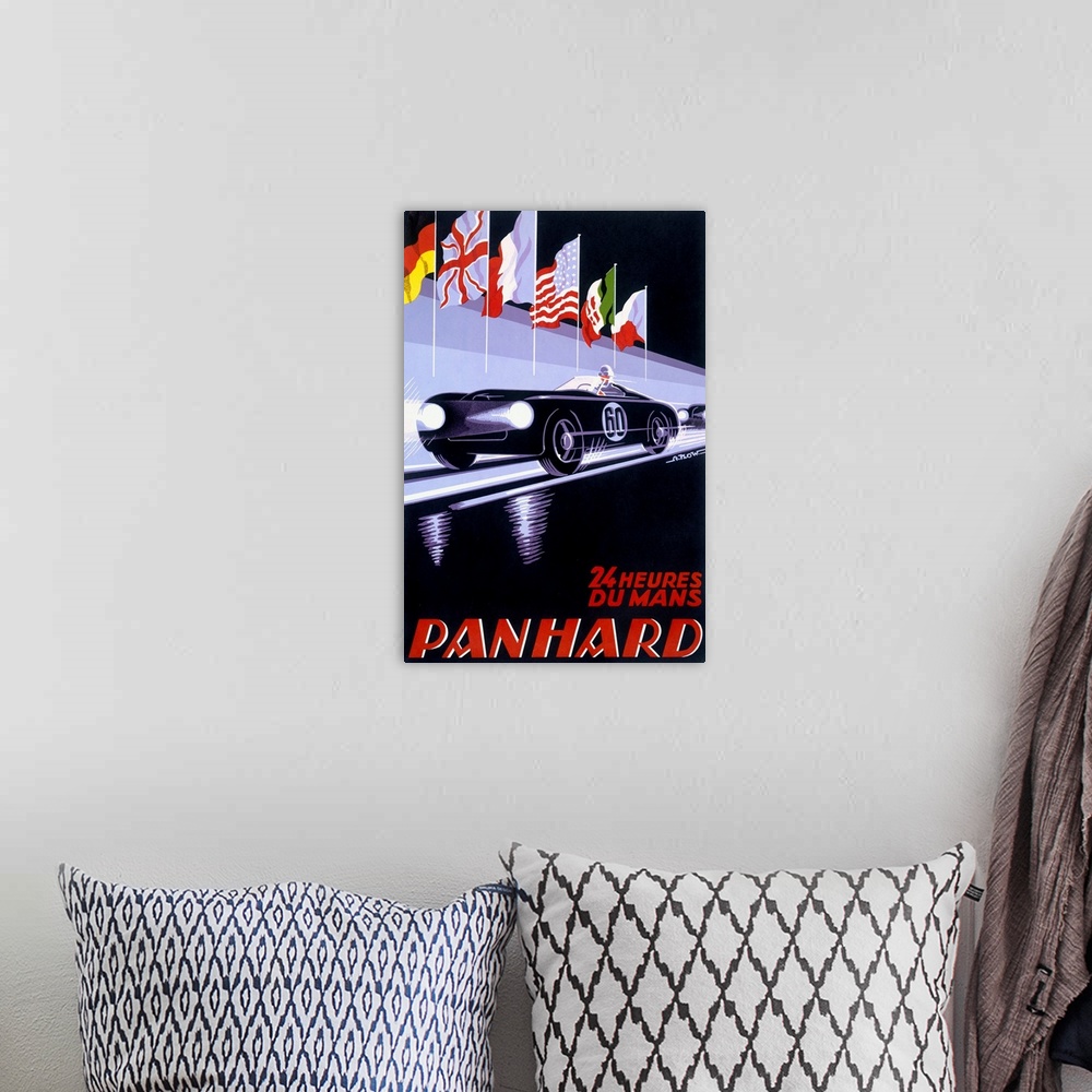 A bohemian room featuring A vertical piece of artwork of a black car racing with flags above it and red text below with the...