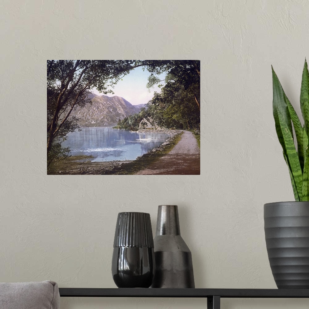 A modern room featuring A vintage shot of a gravel path winding its way at the water's edge as leafy trees and cliffs loo...
