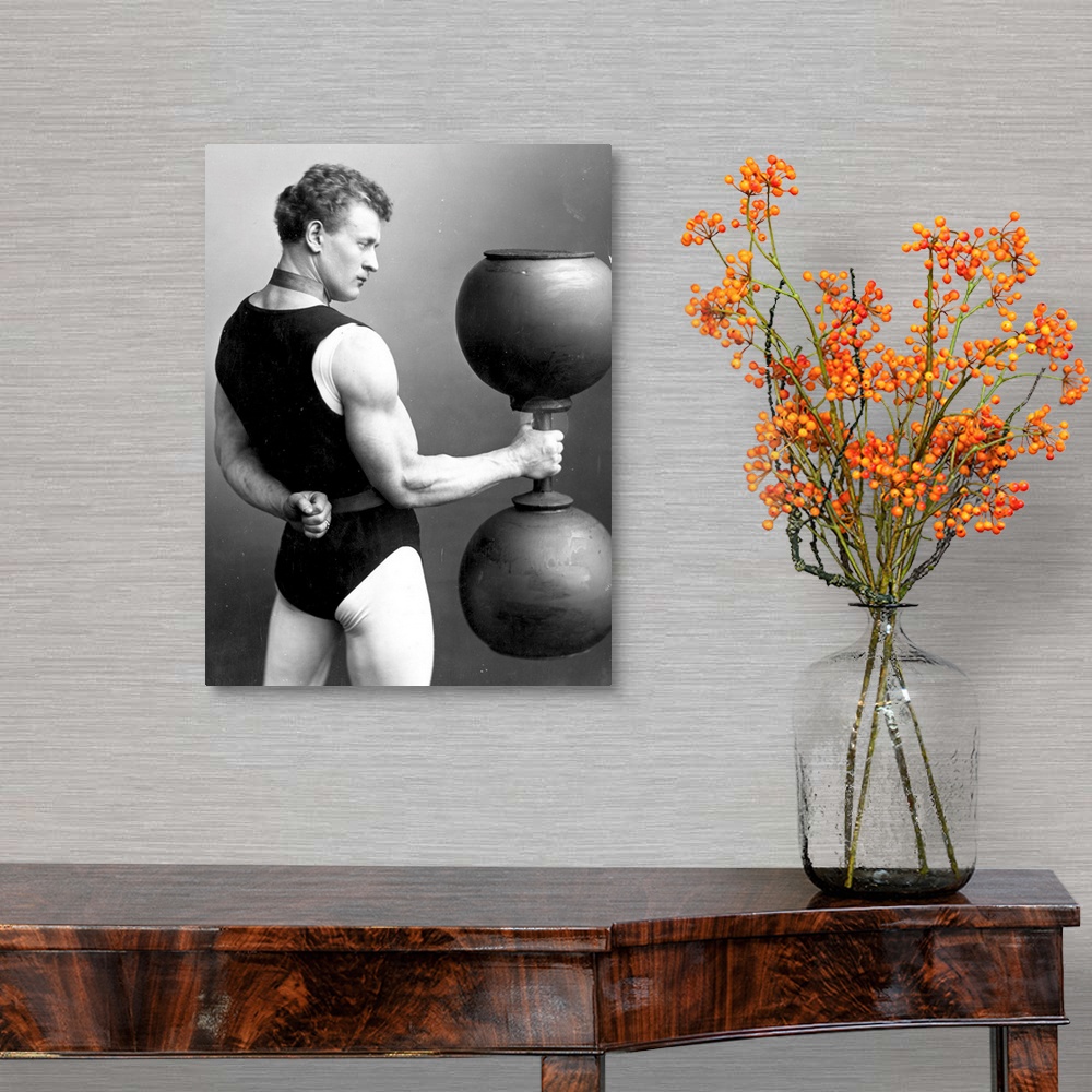 A traditional room featuring circa 1890:  German strongman Eugene Sandow (1867 - 1925) lifting a large dumb-bell